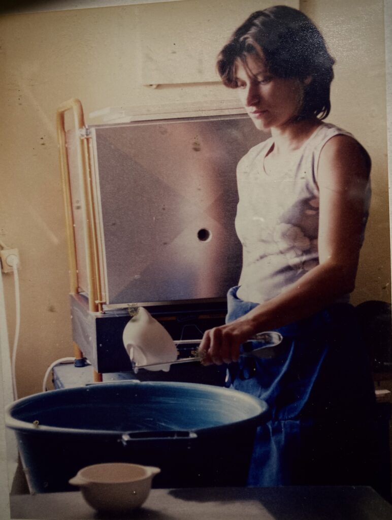 Edith Lartigue entrain d'émailler un bol à oreille dans son atelier de fabrication.